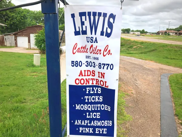 Lewis Cattle Oiler Co. sign, made in the USA, listing the pests an oiler helps control